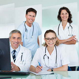 four medical professionals smiling at the camera