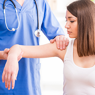 physician helping adjust a person's shoulder and elbow